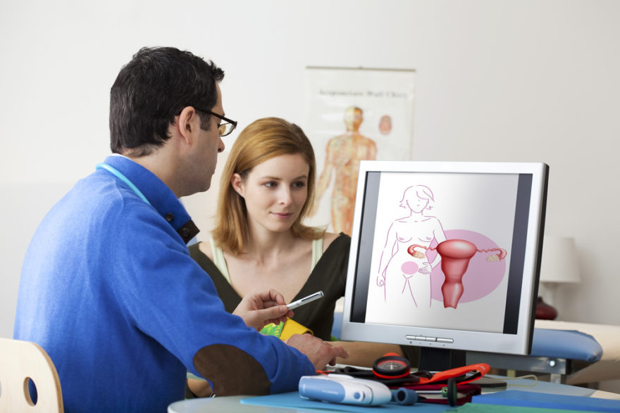 Médico viendo en pantalla de ordenador el órgano reproductor femenino en consulta con motivo del cáncer de cuello uterino o de cervix