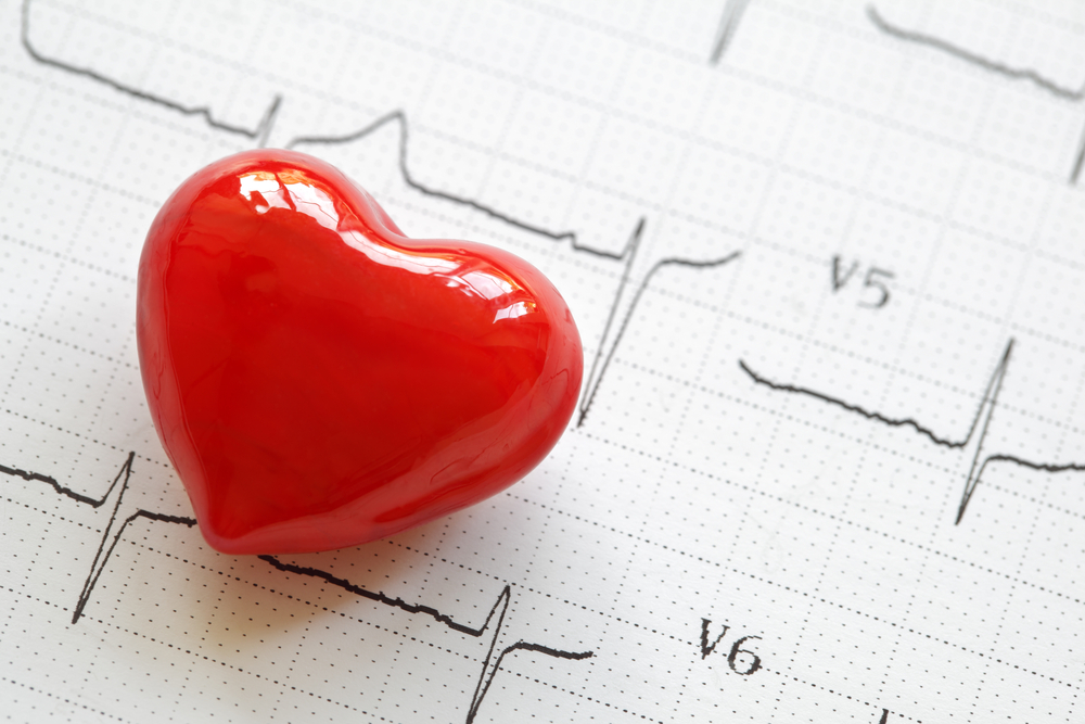 Corazón decorativo sobre electrocardiograma. Concepto de salud cardiovascular y cuidado del corazón.