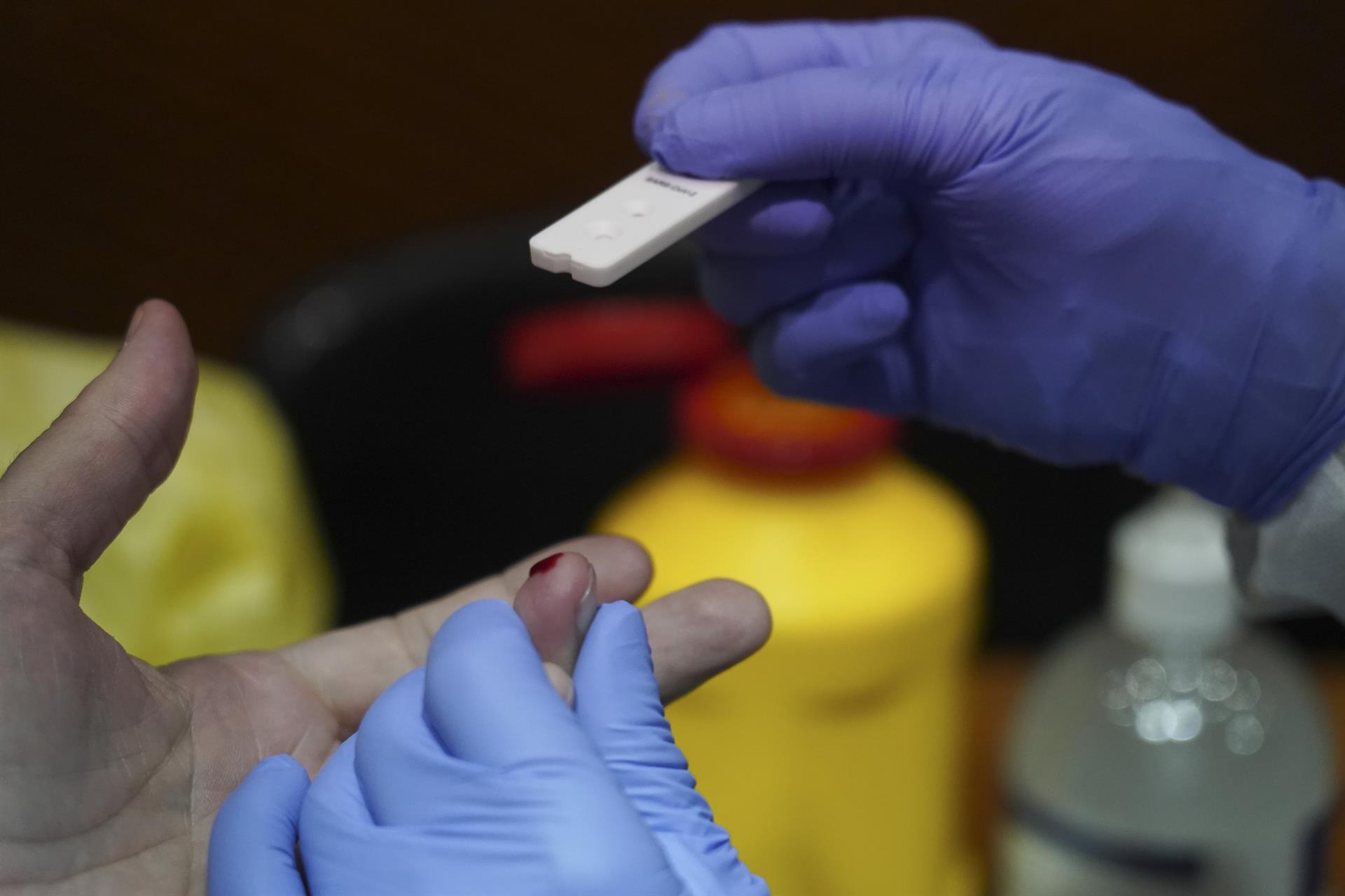 Profesional sanitario analizando la sangre de una persona para determinar el riesgo de infectarse por coronavirus