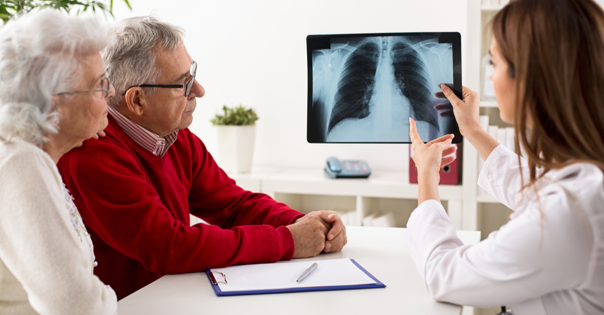 doctora muestra una radiografía a una pareja