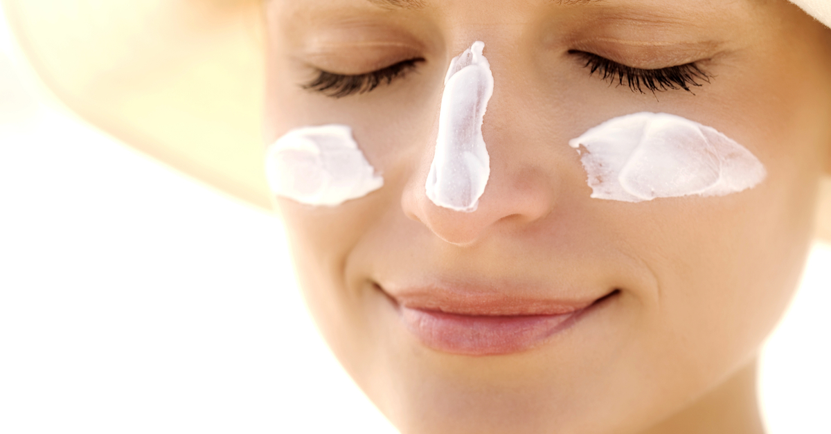 mujer con crema solar en la cara