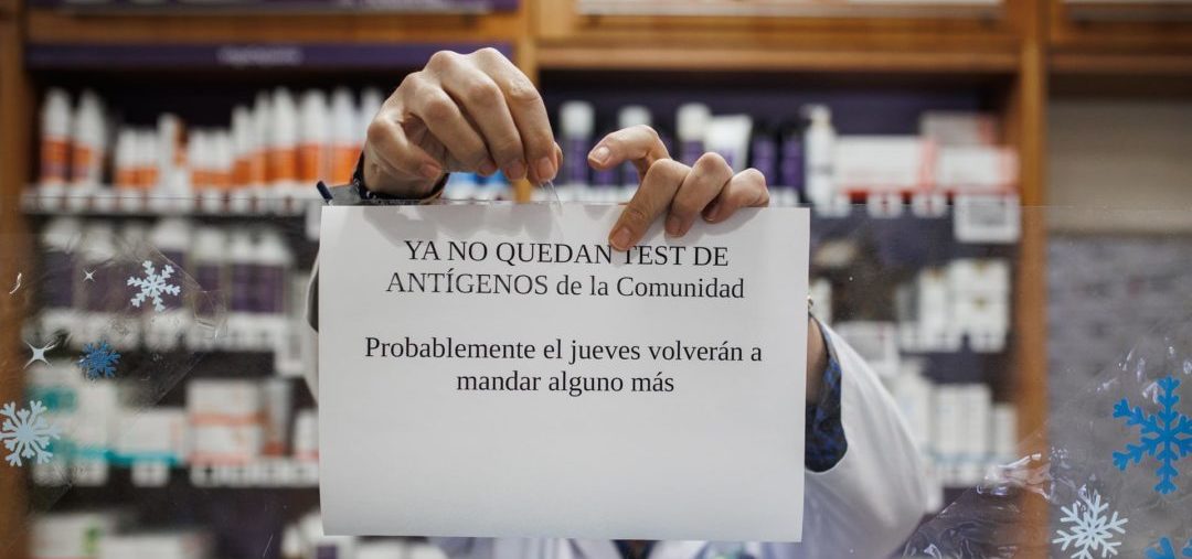 farmacéutico cuelga el cartel de que los test de antígenos de la Comunidad de Madrid están agotados